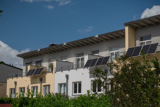 Ein Reihenhaus Mit Einer Solaranlage Auf Den Balkonen Zur Erzeugung Grüner Elektrischer Energie Für Das Zuhause. Balkon-Solarstation Umweltfreundlich Zur Nutzung Erneuerbarer Energie.