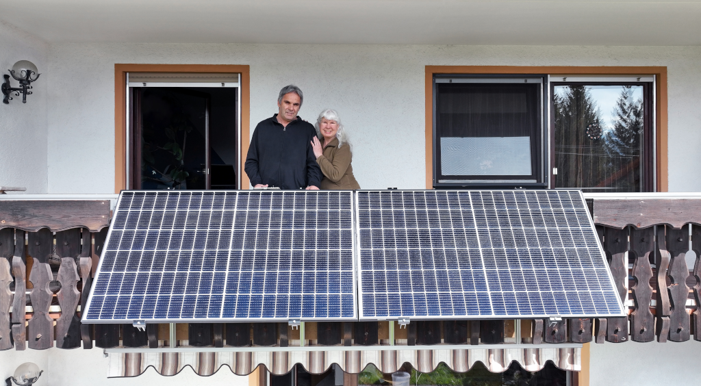 Paar steht auf Balkon mit Balkonkraftwerk